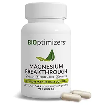 White bottle labeled “BiOptimizers Magnesium Breakthrough” with capsules placed beside it on surface.